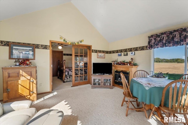 dining area featuring carpet floors and high vaulted ceiling