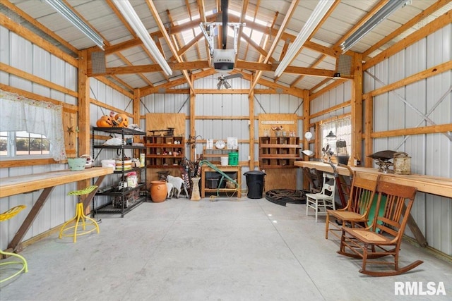 garage featuring a workshop area, wood walls, and a garage door opener