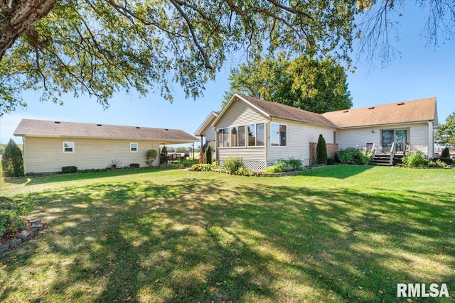 rear view of property with a yard