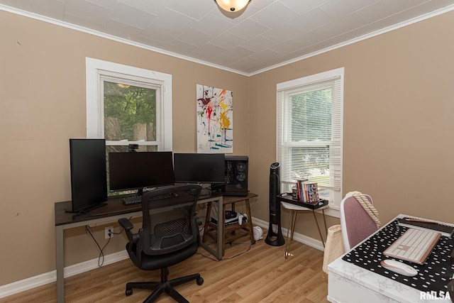 office space with light hardwood / wood-style floors, ornamental molding, and a wealth of natural light