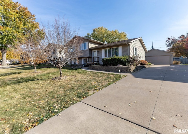 tri-level home featuring a garage, a front lawn, and an outdoor structure