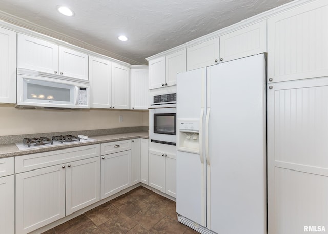 kitchen with white cabinetry, white appliances, and a textured ceiling