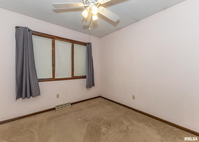 spare room with ceiling fan and light colored carpet