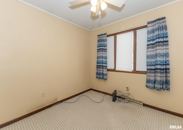 empty room featuring crown molding, ceiling fan, and light colored carpet