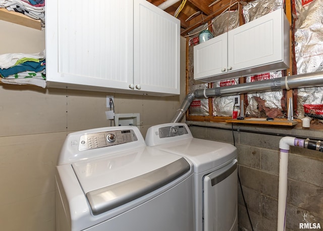 laundry room featuring washing machine and clothes dryer and cabinets