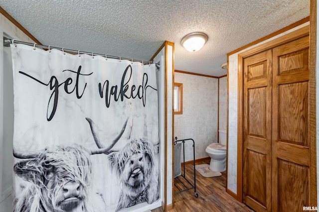 bathroom with hardwood / wood-style floors, a textured ceiling, toilet, and curtained shower