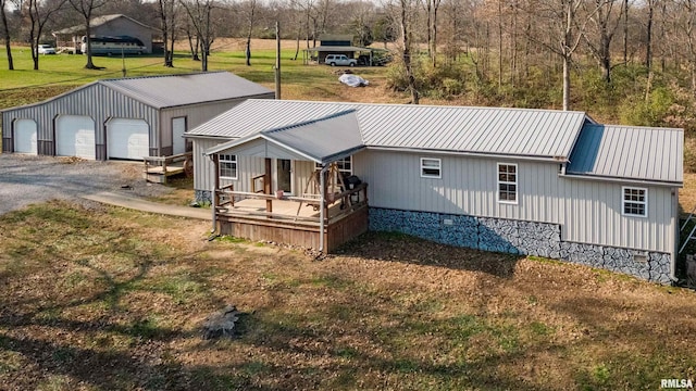 exterior space featuring an outbuilding, a porch, a garage, and a front yard