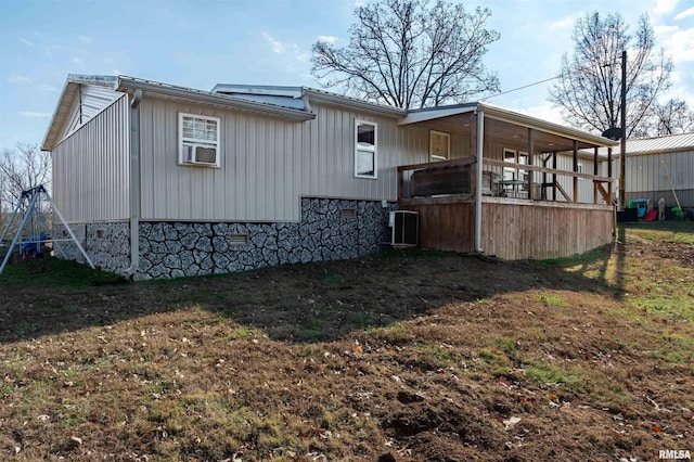 view of side of property with a lawn, a porch, and cooling unit