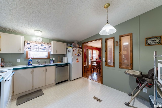 kitchen featuring sink, pendant lighting, lofted ceiling, white appliances, and white cabinets