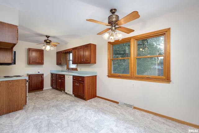 kitchen with light countertops, brown cabinetry, a sink, dishwasher, and baseboards