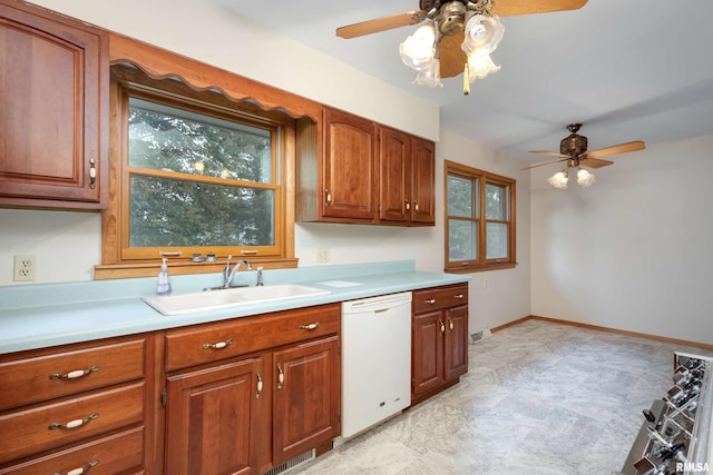 kitchen with baseboards, dishwasher, brown cabinets, light countertops, and a sink