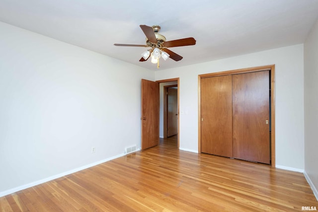 unfurnished bedroom with light wood-type flooring, baseboards, visible vents, and a closet