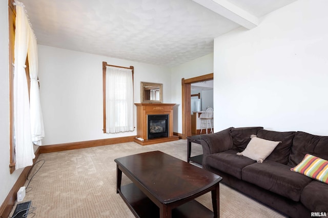 carpeted living room featuring beam ceiling