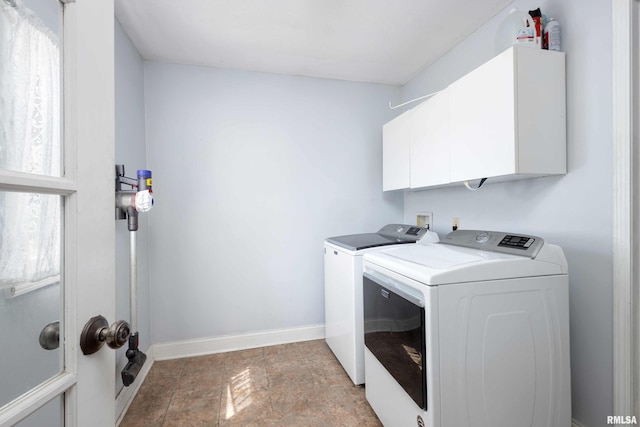 clothes washing area with washer and dryer and cabinets