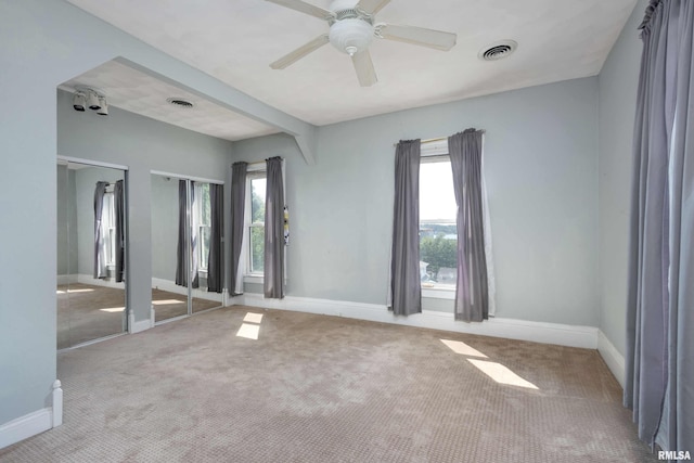 carpeted spare room featuring ceiling fan