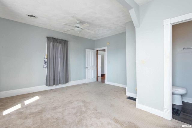 unfurnished bedroom featuring ensuite bath, light carpet, and ceiling fan