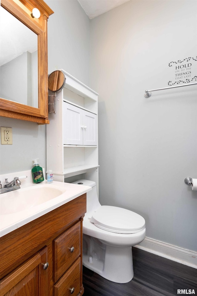 bathroom featuring vanity, wood-type flooring, and toilet