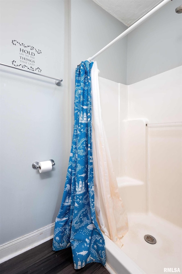 bathroom with a shower with shower curtain and wood-type flooring