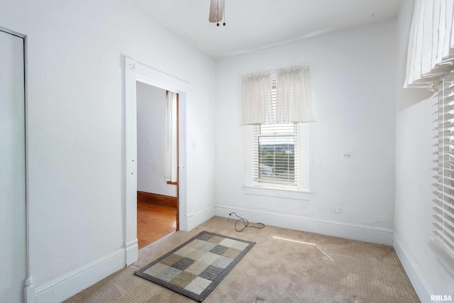 unfurnished room featuring ceiling fan and light carpet