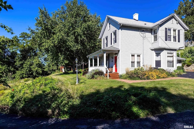 view of property exterior with a yard and a porch