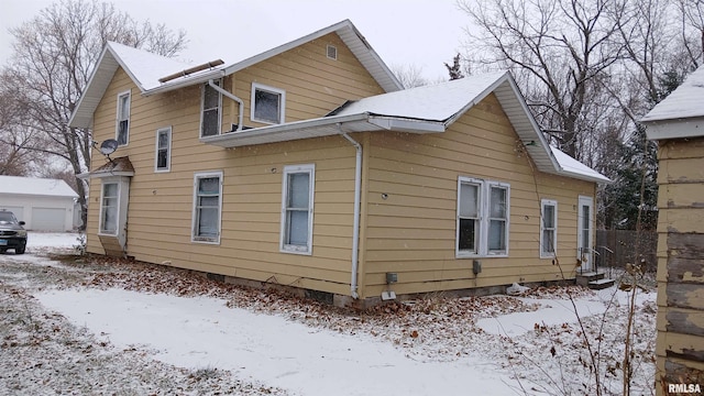 snow covered property with an outdoor structure