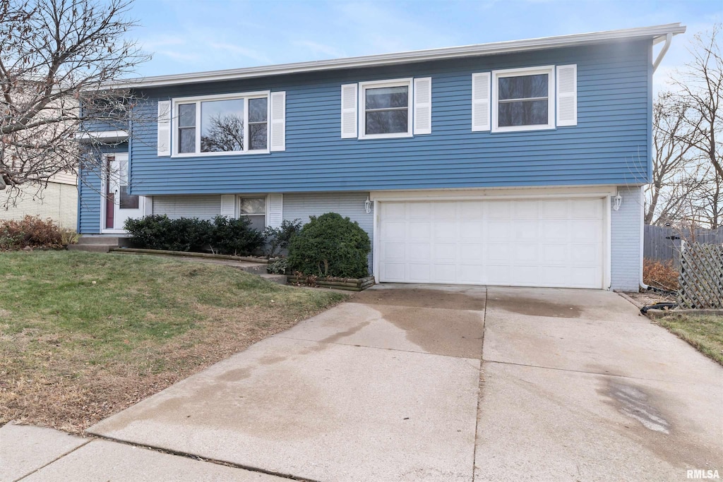 split foyer home featuring a garage and a front lawn