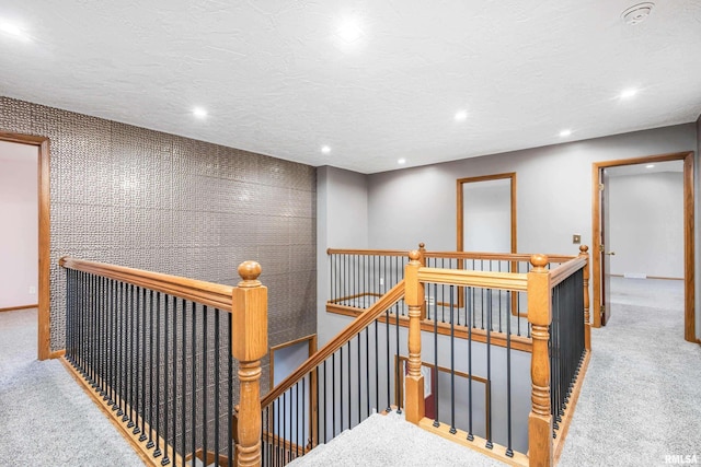 hallway with carpet floors and a textured ceiling