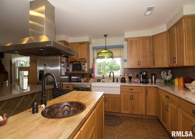 kitchen featuring wood counters, appliances with stainless steel finishes, sink, and range hood