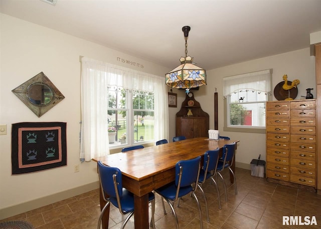 dining area featuring dark tile patterned flooring