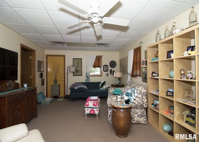 carpeted living room with a paneled ceiling and ceiling fan