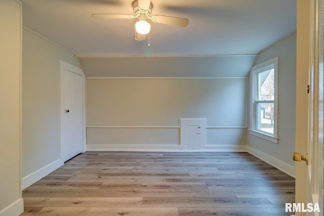 additional living space with light hardwood / wood-style floors, vaulted ceiling, and ceiling fan