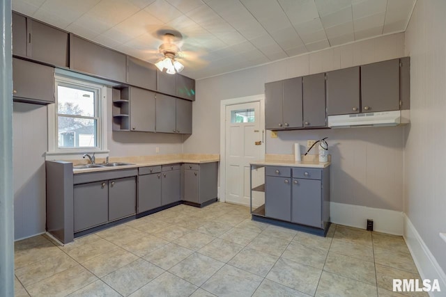 kitchen with gray cabinetry, light tile patterned floors, and sink