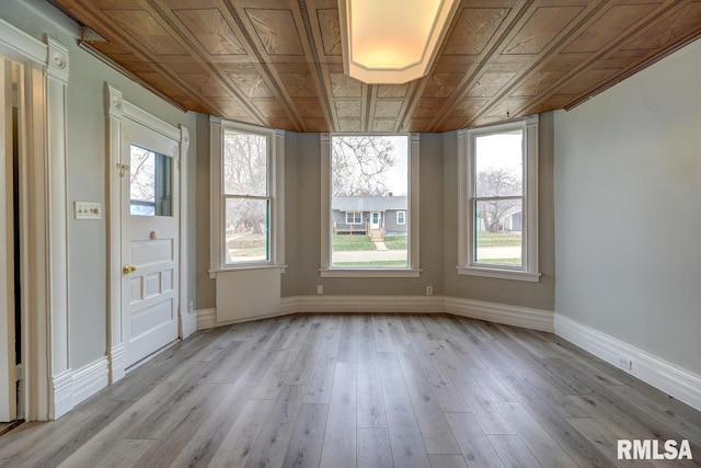 interior space with crown molding, a wealth of natural light, and light hardwood / wood-style flooring