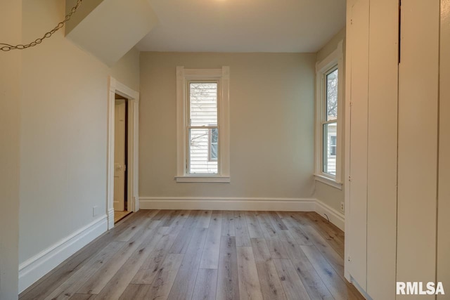 spare room featuring a healthy amount of sunlight and light hardwood / wood-style flooring