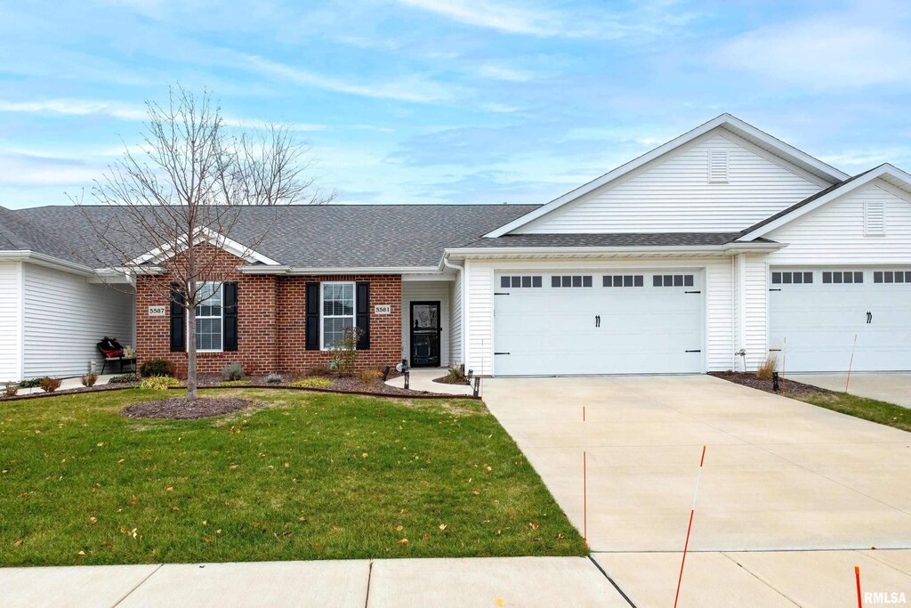 ranch-style house with a front yard and a garage