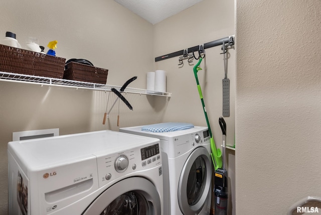 laundry area with washing machine and dryer and a textured ceiling