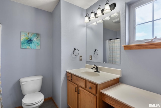 bathroom featuring vanity, toilet, and a textured ceiling