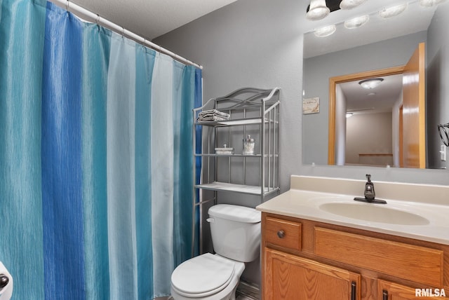 bathroom featuring a textured ceiling, vanity, and toilet