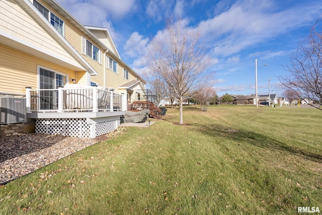 view of yard with central AC unit and a deck