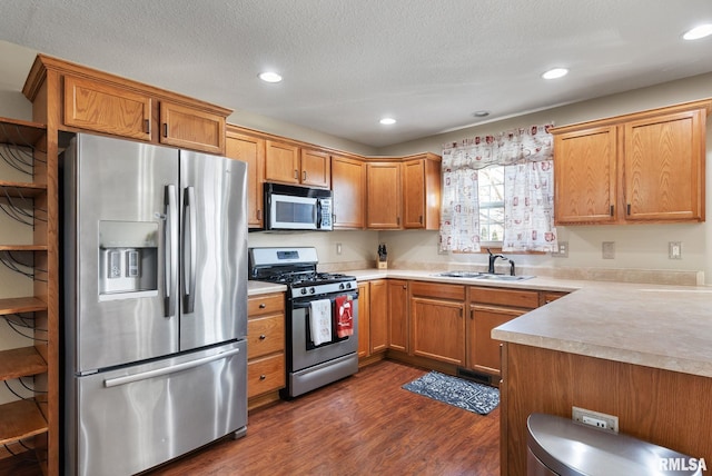 kitchen with a textured ceiling, sink, stainless steel appliances, and dark hardwood / wood-style floors