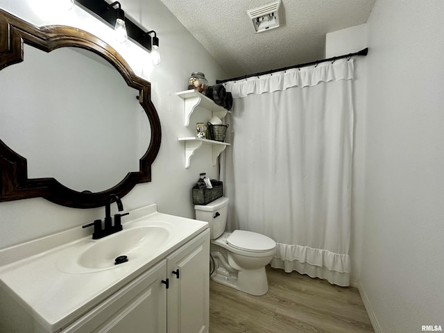 bathroom featuring walk in shower, vanity, a textured ceiling, wood-type flooring, and toilet