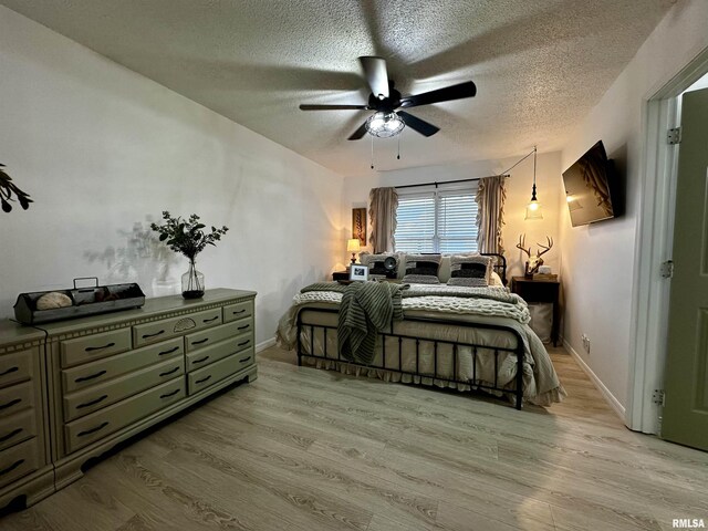 bedroom with ceiling fan, a textured ceiling, and light wood-type flooring