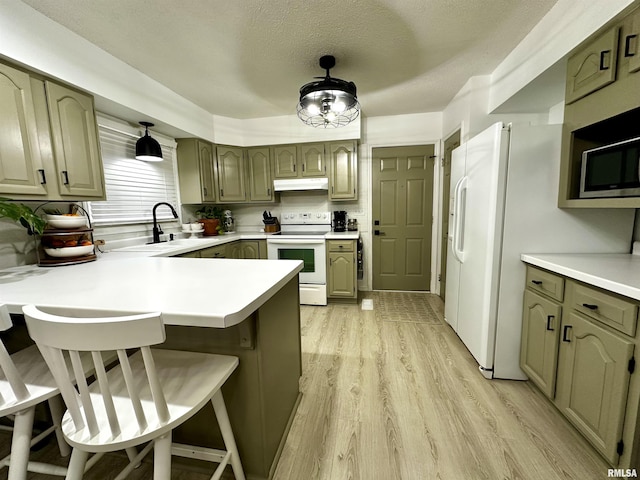 kitchen featuring kitchen peninsula, a textured ceiling, light hardwood / wood-style flooring, white range with electric cooktop, and a breakfast bar area