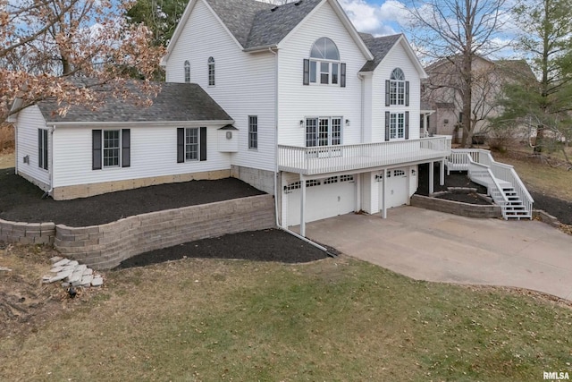 rear view of property with a deck and a garage