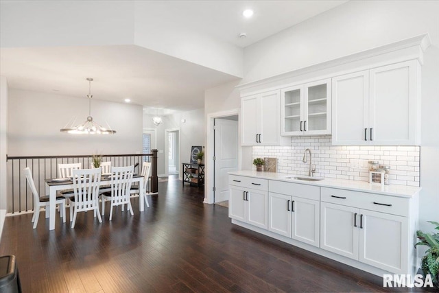 kitchen with pendant lighting, dark hardwood / wood-style floors, white cabinetry, and sink