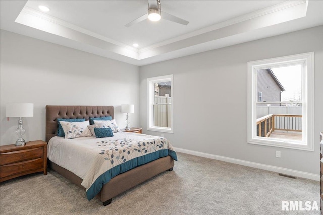 carpeted bedroom featuring ceiling fan, a raised ceiling, and crown molding