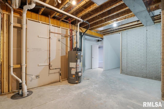 basement featuring brick wall and water heater