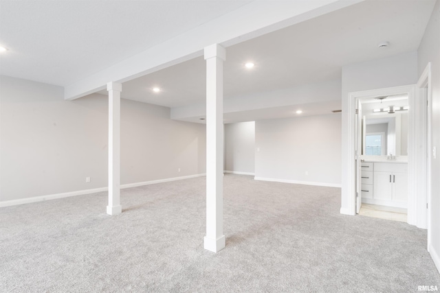 basement with sink and light carpet