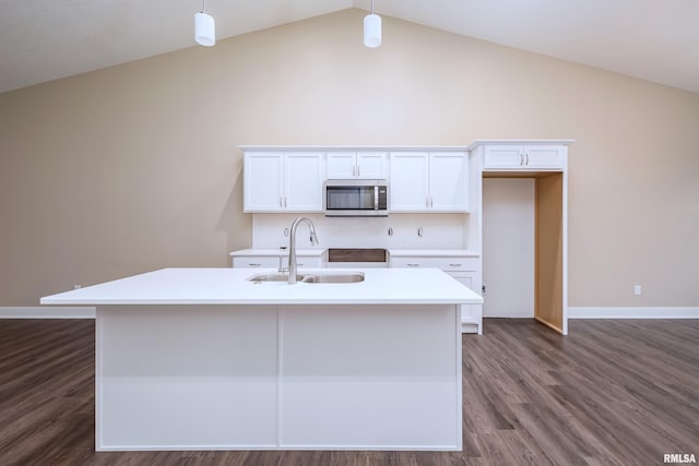 kitchen featuring white cabinets, sink, hanging light fixtures, and an island with sink