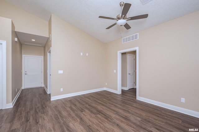 empty room featuring a textured ceiling, ceiling fan, lofted ceiling, and dark wood-type flooring